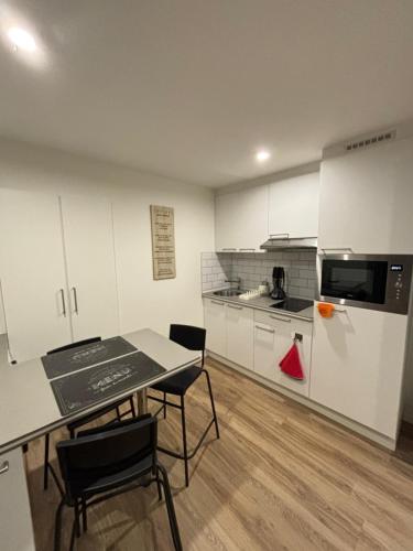 a kitchen with a table and chairs in a room at Le Gîte des petits Loups in Walbourg