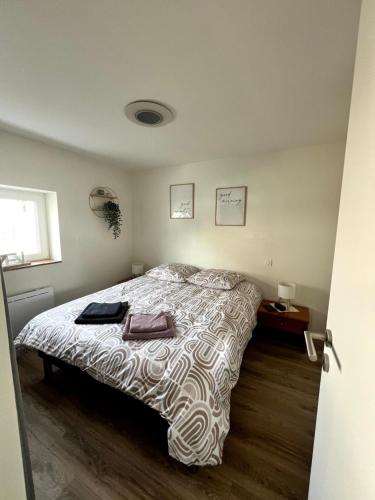 a bedroom with a bed with a comforter on it at Le Gîte des petits Loups in Walbourg