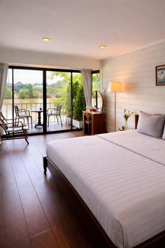 a bedroom with a large bed and a balcony at Baan Keang Chon Ayutthaya บ้านเคียงชล อยุธยา in Phra Nakhon Si Ayutthaya
