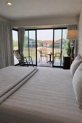 a bedroom with a large bed and a balcony at Baan Keang Chon Ayutthaya บ้านเคียงชล อยุธยา in Phra Nakhon Si Ayutthaya
