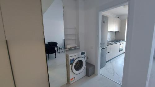 a kitchen with a washing machine in a room at 85th Pool View Studio in Popeşti-Leordeni