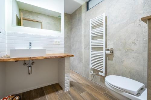 a bathroom with a white toilet and a sink at Gîte DDS - Bridge into nature! in Manhay