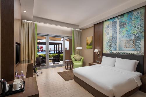 a bedroom with a bed and a living room at Radisson Blu Hotel & Resort, Sohar in Sohar