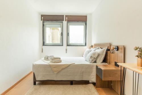 a bedroom with a bed and two windows at DouroParadise Apartment in Peso da Régua