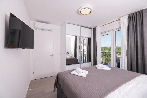 a bedroom with a bed with two towels on it at Villa IviCasa with pool in Murvica
