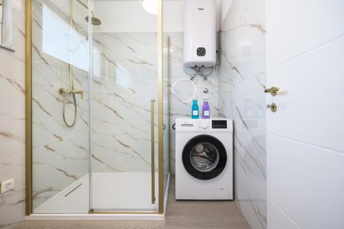 a washing machine in a bathroom with a glass door at Villa IviCasa with pool in Murvica