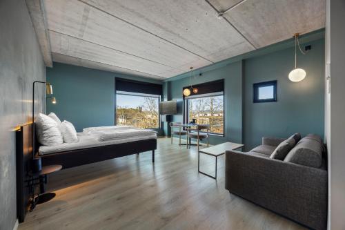 a bedroom with a bed and a couch at Comfort Hotel Porsgrunn in Porsgrunn