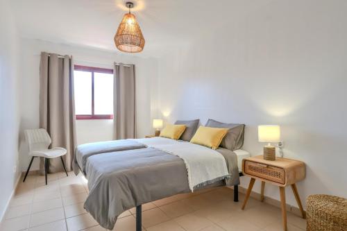 a bedroom with a bed and a table and a chair at La Casa del Toro in Corralejo