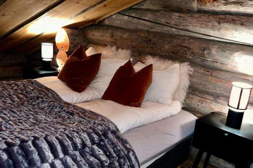 a bed in a log cabin with pillows on it at Exclusive Cabin with lovly Northern Lights Views in Kilpisjärvi
