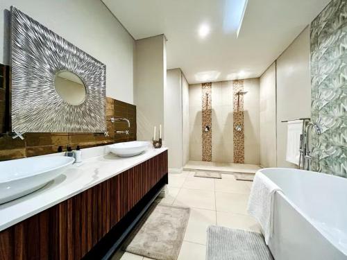 a bathroom with two sinks and a tub and a mirror at 3066 Water Edge in Parys