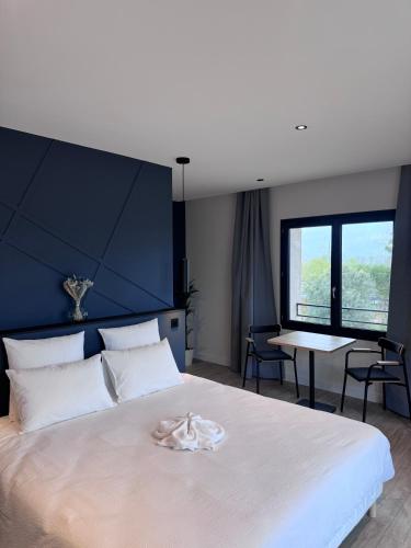 a bedroom with a large white bed and a table at Gîtes les rives de Saône in Saint-Didier-sur-Chalaronne