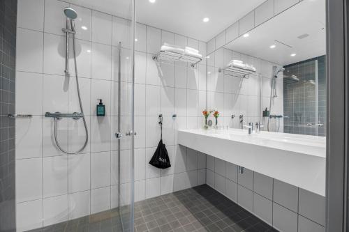 a white bathroom with a shower and a sink at Comfort Hotel Porsgrunn in Porsgrunn