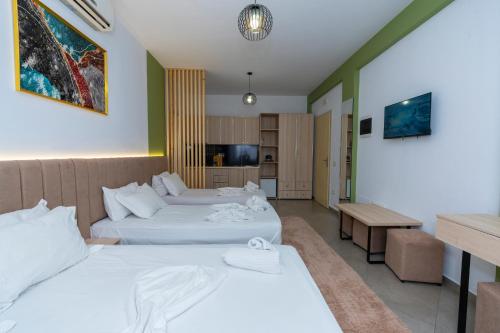 a hotel room with two beds and a kitchen at Hotel Shkodra L in Shkodër