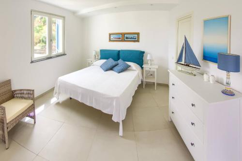a white bedroom with a bed and a dresser at Villa Giannetta in Canneto