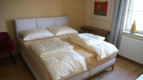 a bed with two pillows on it in a bedroom at Haus Königsreiter, der besondere Platz in Altmünster