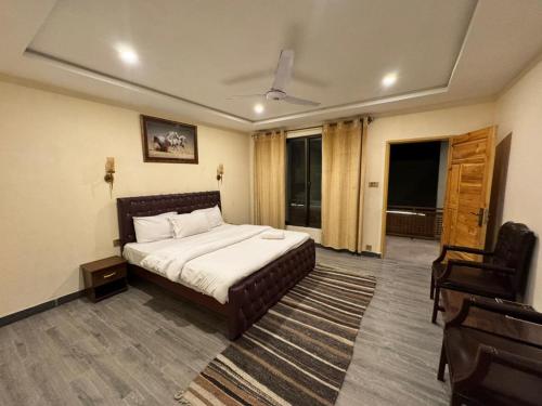 a hotel room with a bed and a chair at Pak Himalaya Hotel Kachura in Ponedas