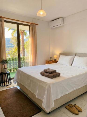 a bedroom with a large white bed with a large window at Blue Lemon Hideaway in Poros