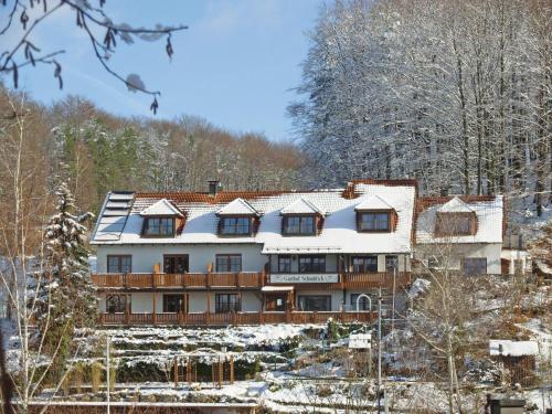 a large house with snow on its roof at Hotelchen Schönblick in Gößweinstein