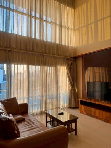 a living room with a couch and a large window at 42Grand Residence in Bangkok