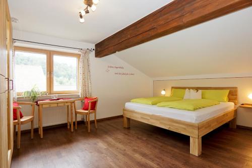 a bedroom with a bed and a desk and a window at Stöcklhof in Siegsdorf