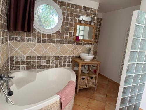 a bathroom with a bath tub and a sink at Villa Lavezzi avec piscine in Bonifacio