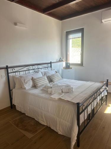 a bedroom with a large bed with white sheets and a window at Bijoux 2 in Celano