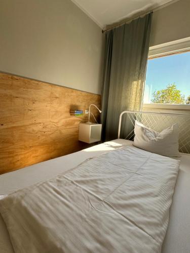 a bedroom with a white bed and a window at Ferienwohnung VIER Hof Himmelgrün in Saal