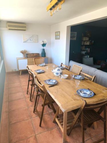 a wooden table in a living room with chairs at Le spacieux - centre ville in Gap