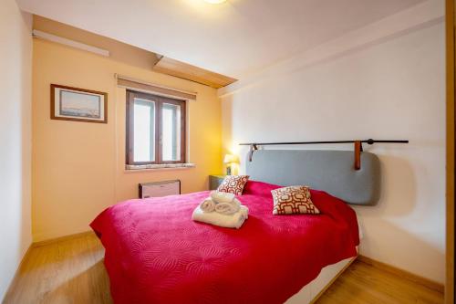 a bedroom with a red bed with two towels on it at Guest Art Campitello Matese in Campobasso
