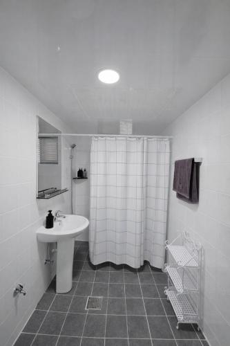 a bathroom with a shower curtain and a sink at 메종 블랑 서울 in Seoul