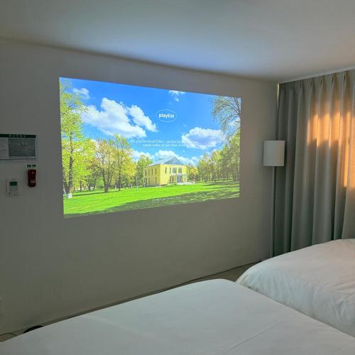 a tv hanging on a wall in a bedroom at 메종 블랑 서울 in Seoul