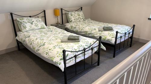 two twin beds in a room with a staircase at Poachers Hut 1-Bed Cottage Sleeps 2 Pet Friendly in Shorwell