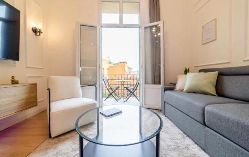 a living room with a couch and a glass table at MONTE CARLO BORDER - exclusive & modern flat in Beausoleil