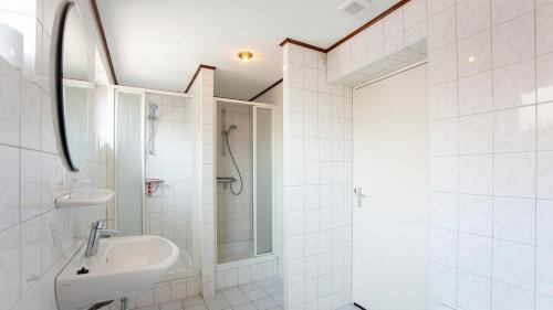 a white bathroom with a sink and a shower at Vakantie oord Zonnehoeve in Valkenburg