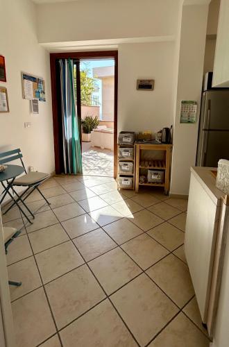a kitchen with a large tiled floor with a refrigerator at Arcobaleno Tropea centro in Tropea