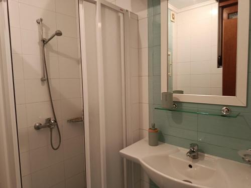a bathroom with a sink and a shower with a mirror at Blue Marina Sunset in Sozopol