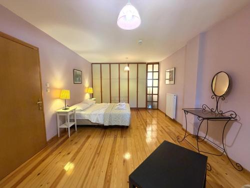 a bedroom with a bed and a table and a mirror at Sunlit Village Escape in Kompítsion