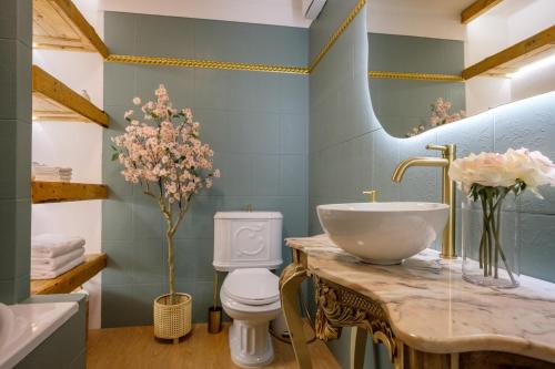 a bathroom with a sink and a toilet and a mirror at Casa Rosa Sé - Luxury Boutique Guest House in Faro
