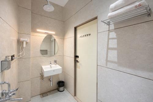 a bathroom with a sink and a shower at Sharda Grand in Ujjain