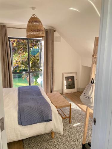 a bedroom with a bed and a large window at Rhubarb Cottage in Navan