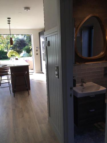 a bathroom with a sink and a mirror and a table at Rhubarb Cottage in Navan