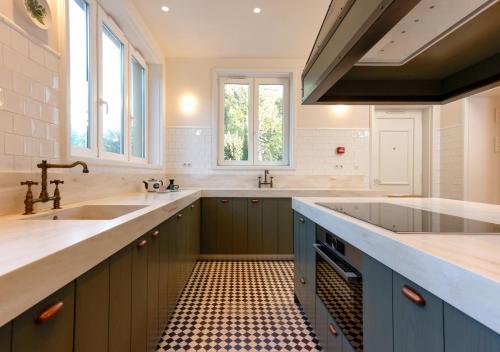 a large kitchen with a sink and two sinks at Montebelo Vista Alegre Ílhavo Hotel in Ílhavo