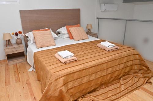 a bedroom with a large bed with two towels on it at Olympus Pool Retreat in Katerini