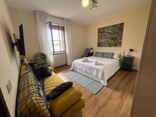 a bedroom with a bed and a couch at The little lake Verona villa in Bovo