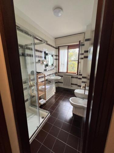 a bathroom with two sinks and a shower and two toilets at The little lake Verona villa in Bovo