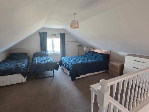 a attic bedroom with two beds and a staircase at Coastal Annex at Saltfleet in Saltfleet