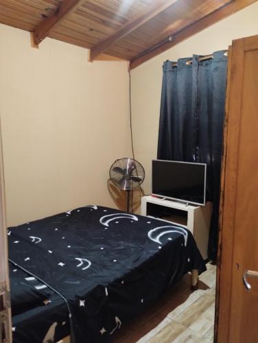 a bedroom with a bed and a television at Hospedaje Cabaña Completa in Rivera