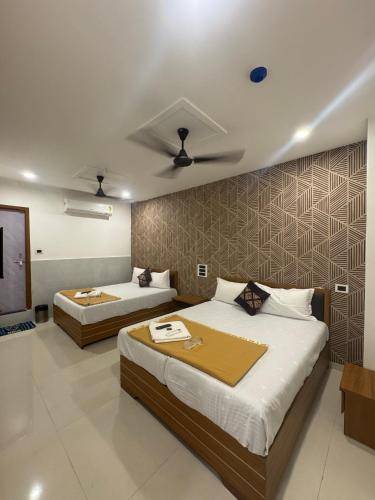 a hotel room with two beds and a tv at Hotel Kalp Rooms in Vyāra