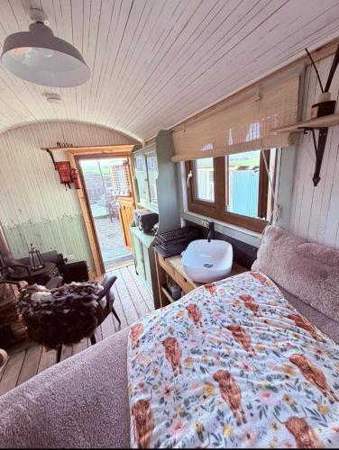 a bedroom with a bed and a couch in a room at The Black Sheep Shepherd's Hut in Prestrie