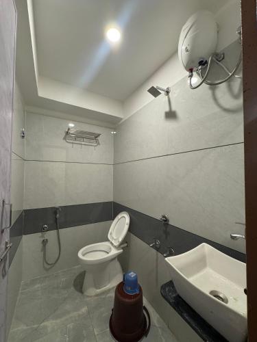 a bathroom with a toilet and a sink at Hotel Kalp Rooms in Vyāra
